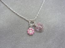 Zilveren kinderkettinkje met roze bloem en vlinder.